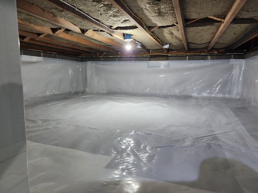 White crawl space vapor barrier covering the ground and wrapping the walls and support pier